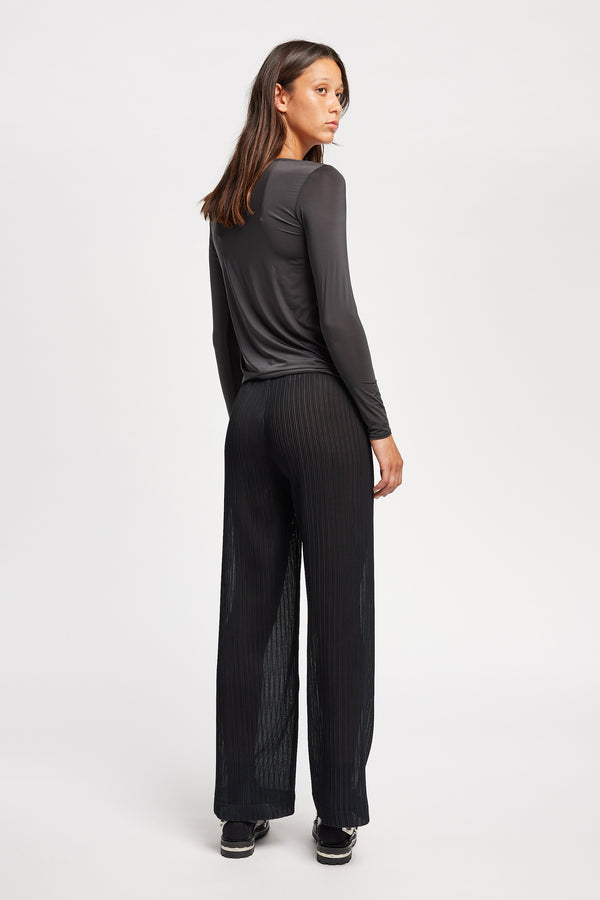 Back of Model in the black Trace Pant crafted from a recycled Japanese polyester with a relaxed straight leg and elastic waistband. 