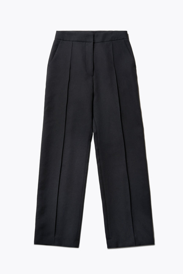 Flat Back view of the Tranquillity Pant in black, a slim-fit stovepipe-style tailored pant with pin tuck detailing.