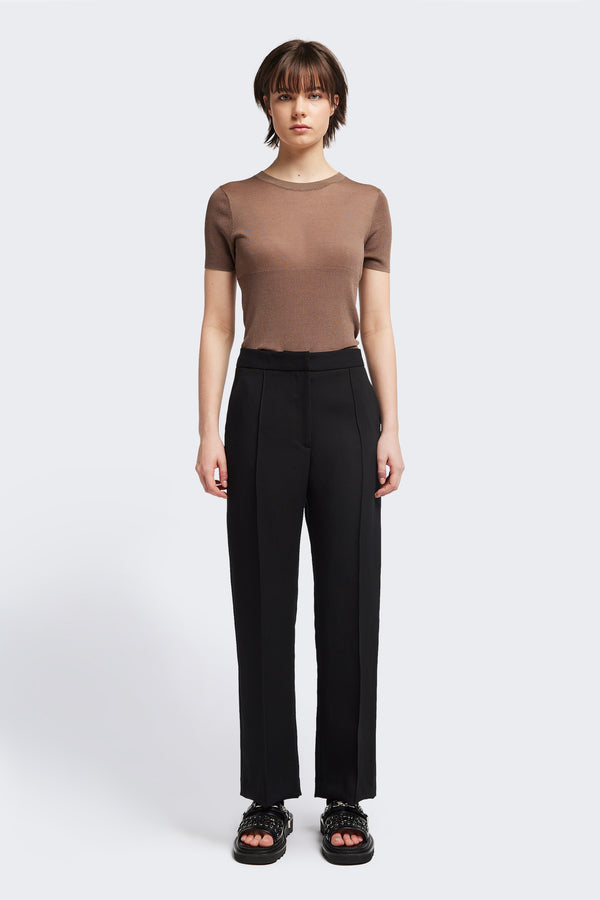 Front view of the Tranquillity Pant in black, a slim-fit stovepipe-style tailored pant with pin tuck detailing.