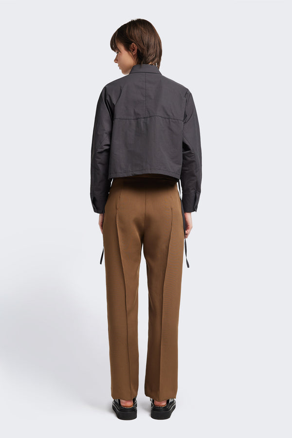 Back view of the Tranquillity Pant in brown, a slim-fit stovepipe-style tailored pant with pin tuck detailing.
