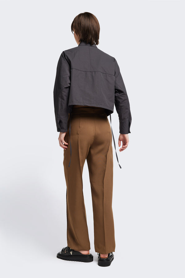 Back view of the Tranquillity Pant in brown, a slim-fit stovepipe-style tailored pant with pin tuck detailing.