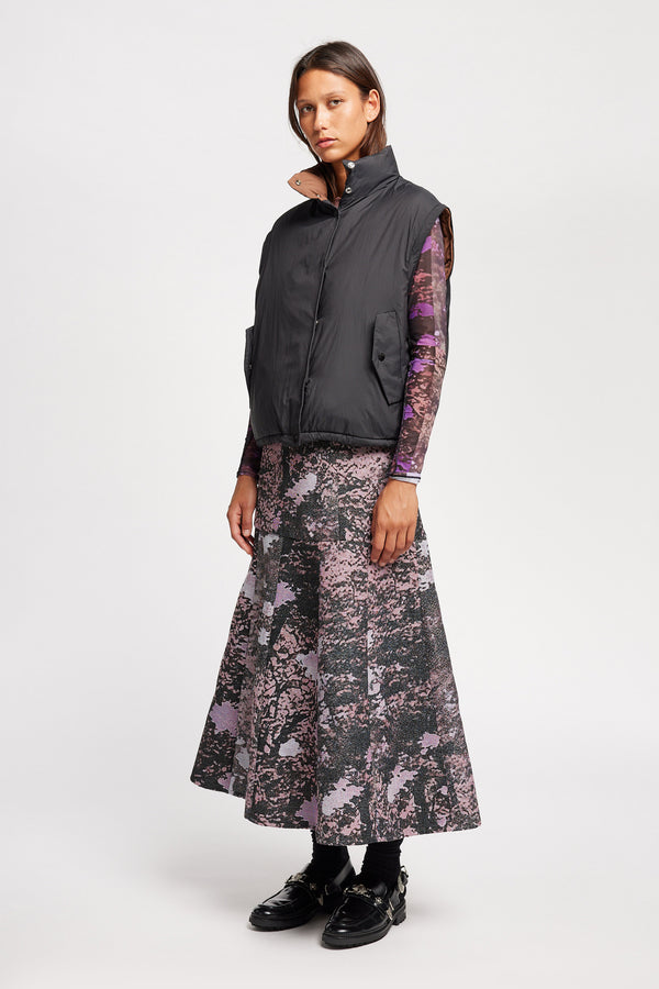 Front Angle view of Model wearing the Transform Puffa Jacket in black with sleeves removed, showcasing cropped length and high collar