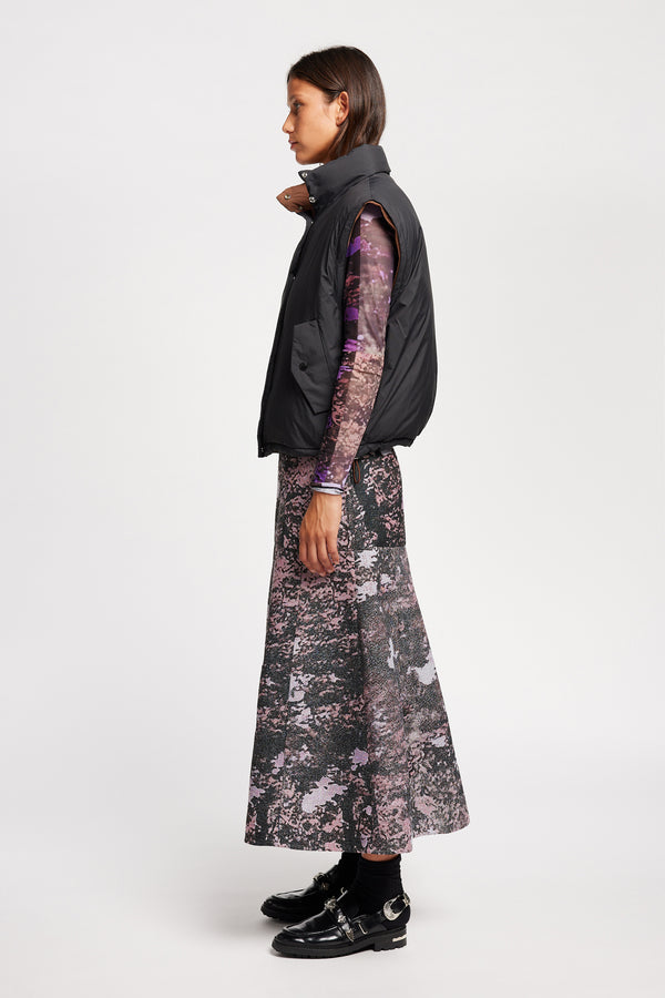 Side view of Model wearing the Transform Puffa Jacket in black with sleeves removed, showcasing cropped length and high collar