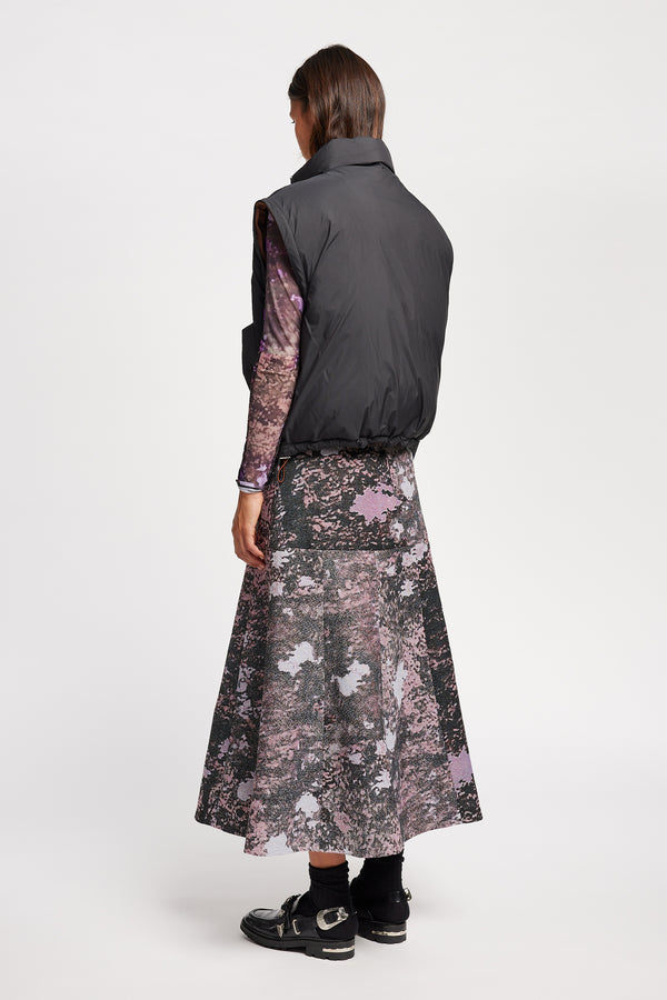 Back view of Model wearing the Transform Puffa Jacket in black with sleeves removed, showcasing cropped length and high collar