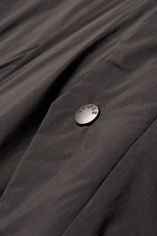 Close-up detail shot of stud button closure on Transform Puffa Jacket on the black side 