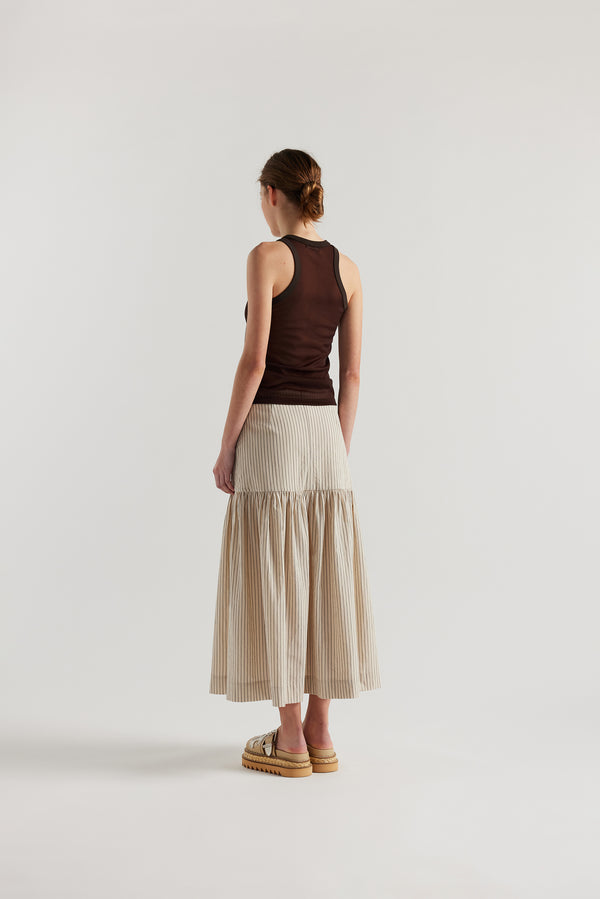 Back view on female model of the Brown Transformation Tank in sheer fabric with racerback neckline.