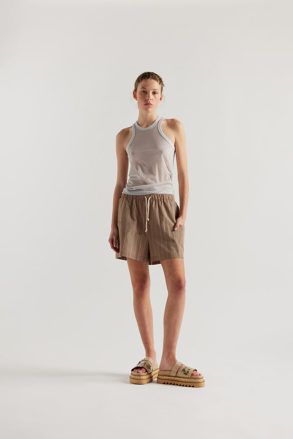 Front view on female model of the Pale Blue Transformation Tank in sheer fabric with racerback neckline.