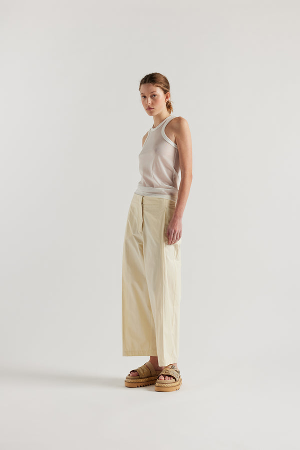 Front angle view on female model of the White Transformation Tank in sheer fabric with racerback neckline.