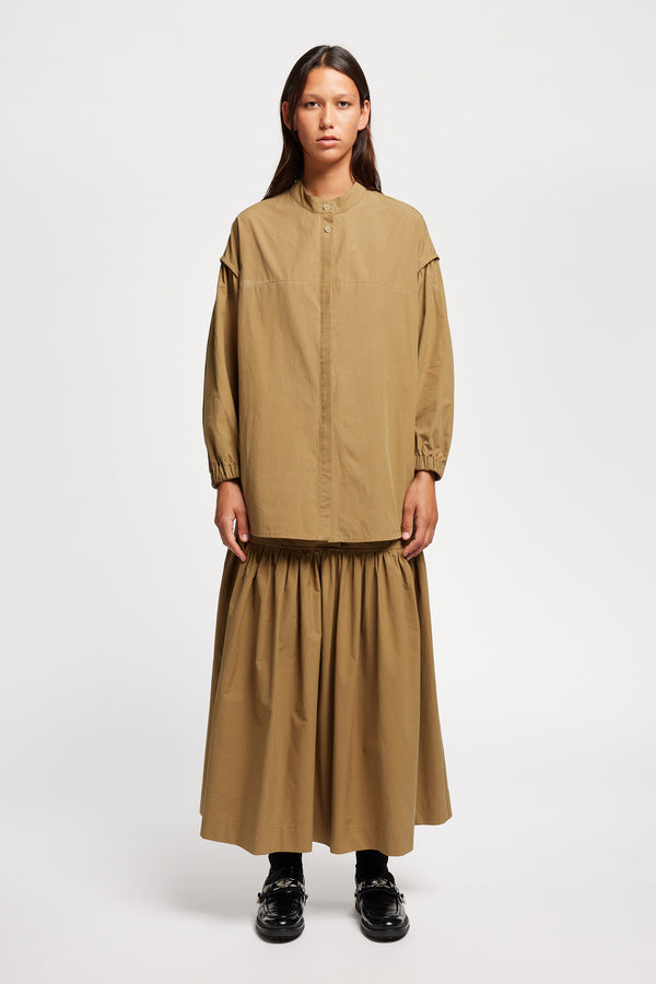 Front view of the Model wearing the Transit Gathered Blouse in Dusty Olive a relaxed band collar shirt with dropped shoulders, pleated sleeves, and a curved hemline.