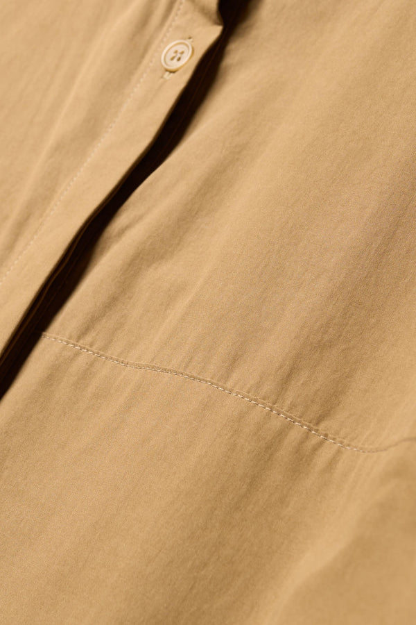 Close up fabric details of the Transit Gathered Blouse in Dusty Olive a relaxed band collar shirt with dropped shoulders, pleated sleeves, and a curved hemline.