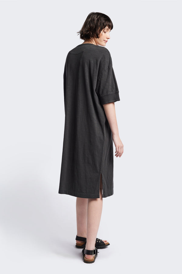 Back of The Treatise Henley Dress in Black soft jersey, featuring a relaxed boxy fit, crew neckline, henley button detail, and falling just below the knee. Available in 5 sizes.