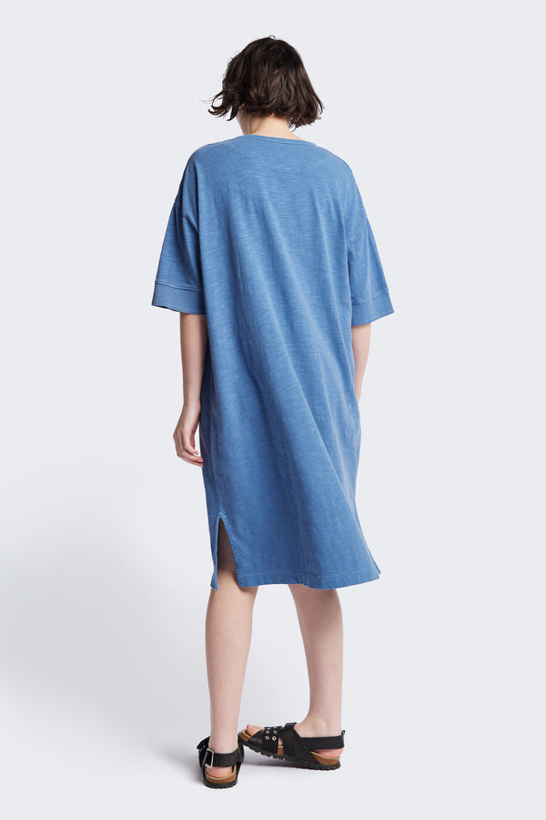 Back of the Treatise Henley Dress in Blue soft jersey, featuring a relaxed boxy fit, crew neckline, henley button detail, and falling just below the knee. Available in 5 sizes.