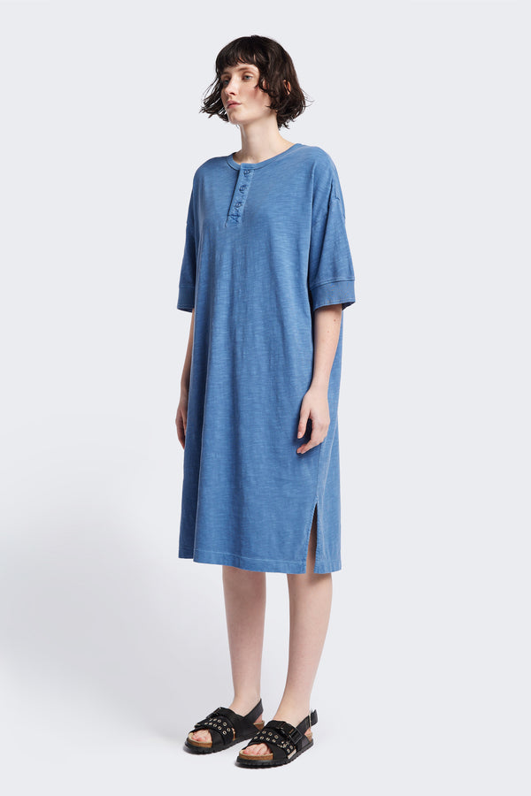 The Treatise Henley Dress in Blue soft jersey, featuring a relaxed boxy fit, crew neckline, henley button detail, and falling just below the knee. Available in 5 sizes.