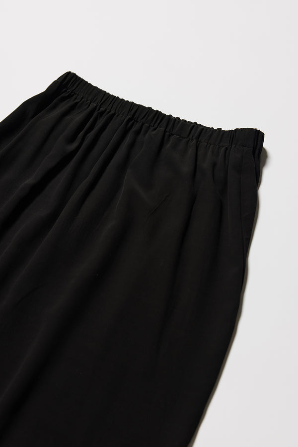 Close-up of slip skirt fabric texture, gathered waist, in black soft viscose-rayon. e.