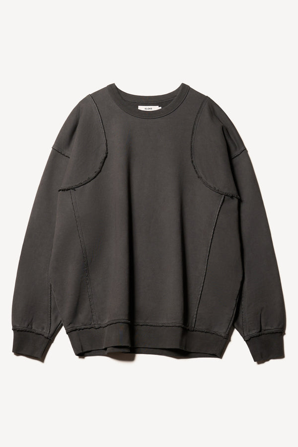 flat front of Unisex format oversized crew neck sweater in jet black  with clean panelled design and raw flat-locked seams, displayed from the front.