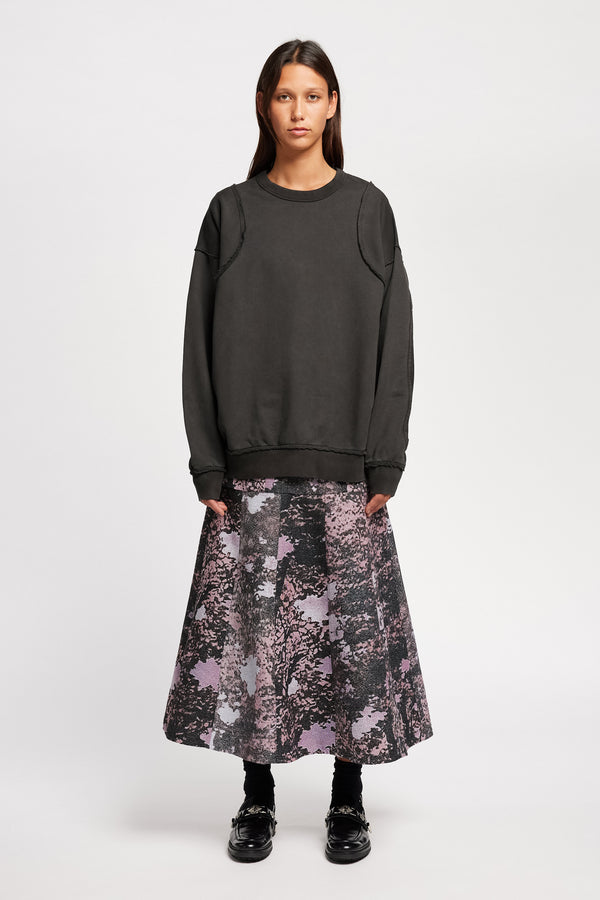 women - front of model wearing Unisex format oversized crew neck sweater in jet black  with clean panelled design and raw flat-locked seams, displayed from the front.