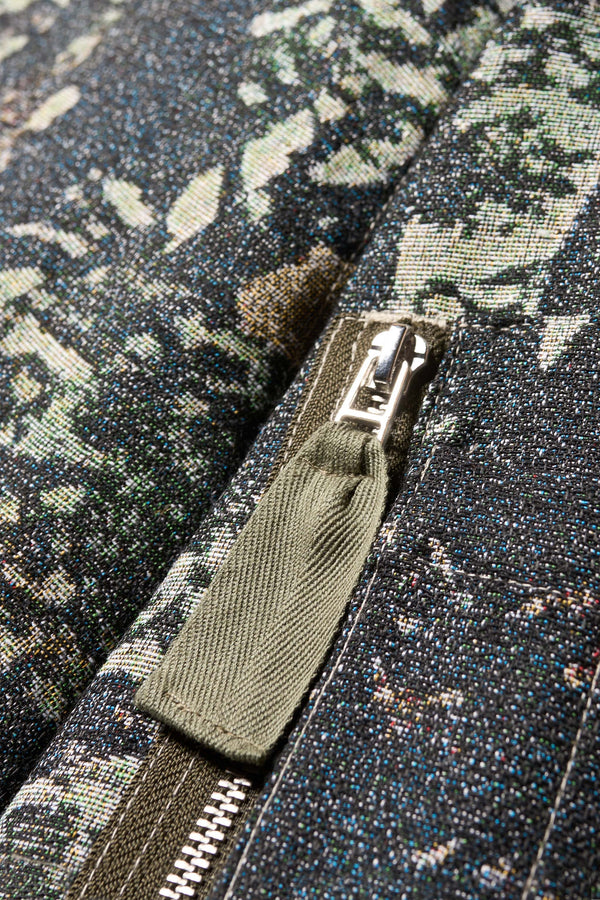 Close up fabric shot of Unisex bomber jacket in Green Print woven jacquard with real tree camouflage, featuring dropped shoulders, ribbed trims, and full-length front zip.