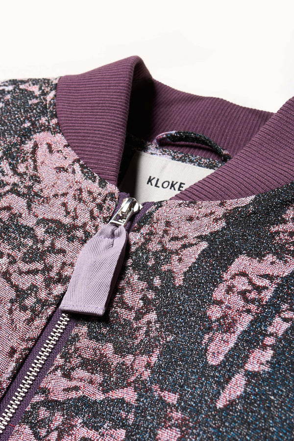 Close up Fabric and collar detail shot of Unisex bomber jacket in Purple Print woven jacquard with real tree camouflage.