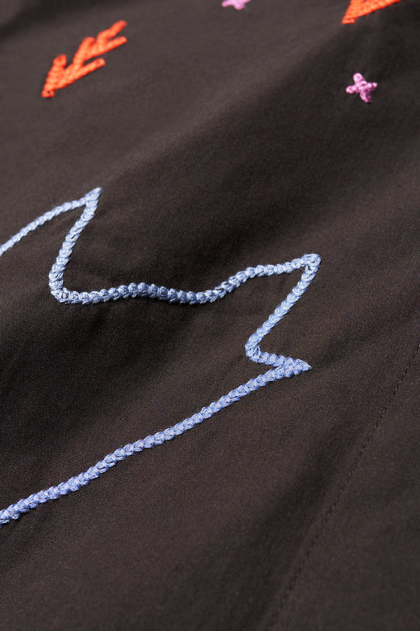 Close up embroidery details of the Black Universe Embroidered Skirt showcasing Arecibo-inspired motifs.