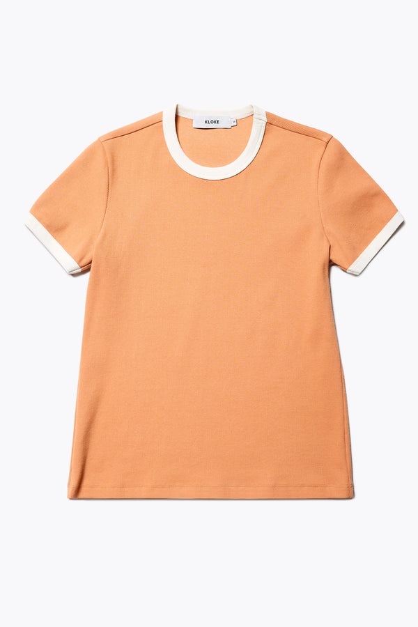 Flat Front of the Veil Rib Tee a slim-fit ringer tee in pastel orange and ecru ribbed cotton, featuring a vintage 70's-inspired design with contrasting neckline and sleeve details. Available in 5 sizes. 