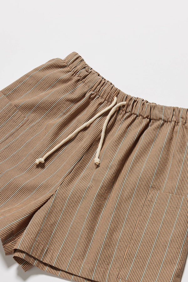 Close up fabric and detail shot of the burnt orange, ecru and black stripe vesper short in 100% Cotton. A wide loose fit short with elasticated waistband. 