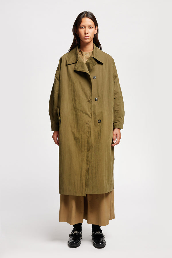 Front view of model wearing the Volt Trench in Kelp Green collar down. A lightweight double-breasted trench coat with flap pockets