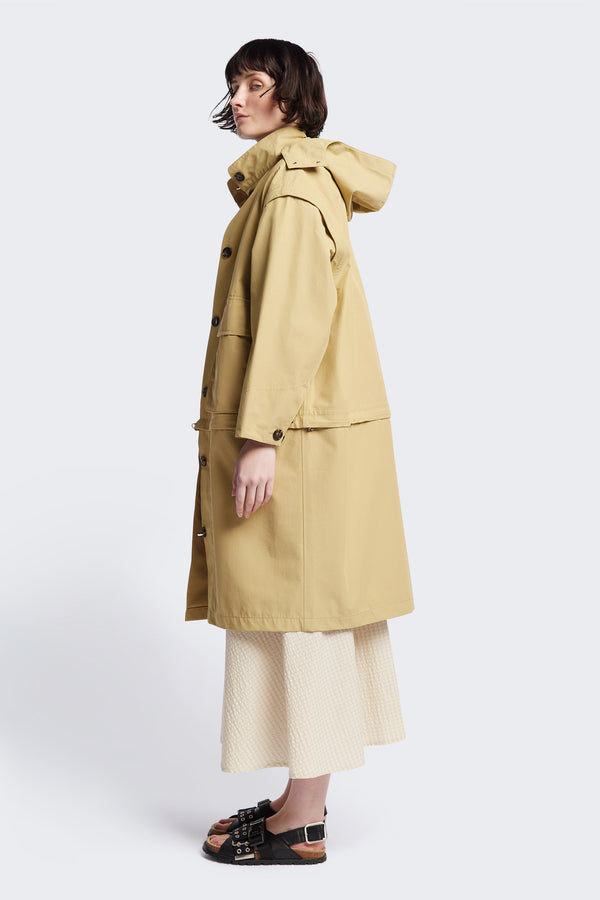 Side of the Vulcan Zip Coat in Sand, an oversized, six-in-one waterproof design with zip-off sleeves and bottom, featuring 3D front pockets, a detachable hood, and a stand collar.