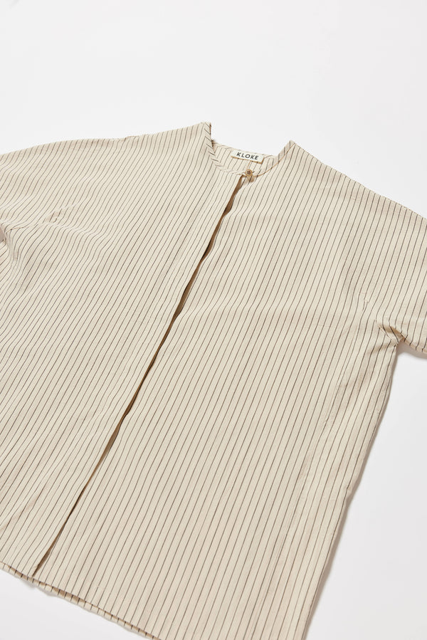 Detail fabric shot of the oversized boxy yarn-dyed cotton top with round crew neck and concealed placket in Ecru with black pin stripe. 
