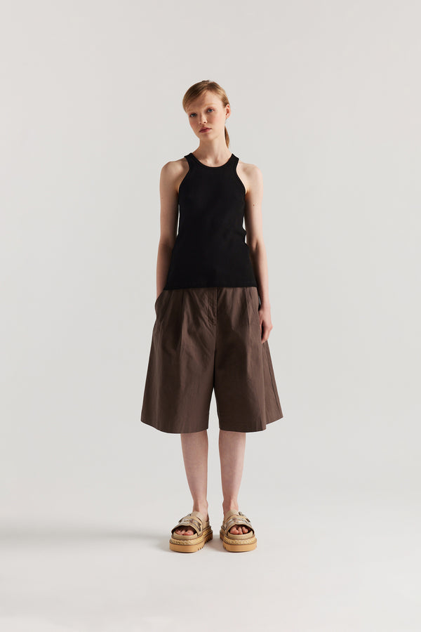 Front of Model wearing the Wing tank in Black. A slim-fit ribbed cotton tank with a slight racer neckline. A clean, minimal silhouette