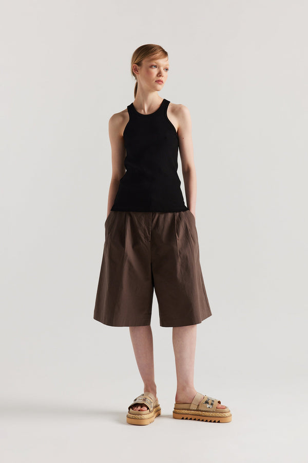 Front of Model wearing the Wing tank in Black. A slim-fit ribbed cotton tank with a slight racer neckline. A clean, minimal silhouette