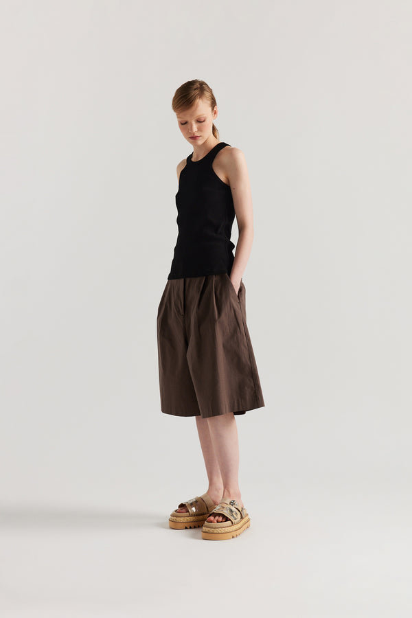 Front Angle of Model wearing the Wing tank in Black. A slim-fit ribbed cotton tank with a slight racer neckline. A clean, minimal silhouette