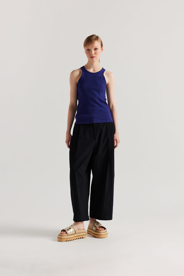 Front of Model wearing the Wing tank in Cobalt blue. A slim-fit ribbed cotton tank with a slight racer neckline. A clean, minimal silhouette