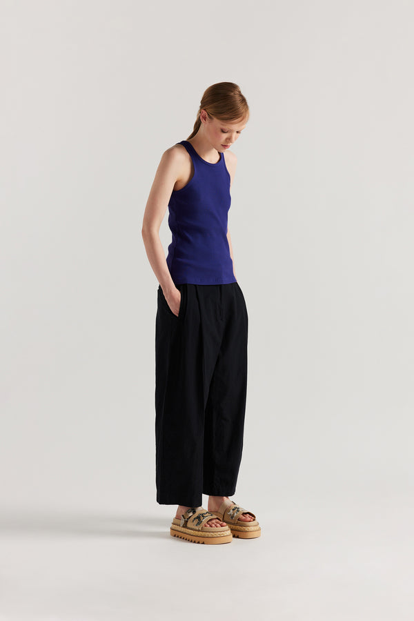 Front angle of Model wearing the Wing tank in Cobalt blue. A slim-fit ribbed cotton tank with a slight racer neckline. A clean, minimal silhouette