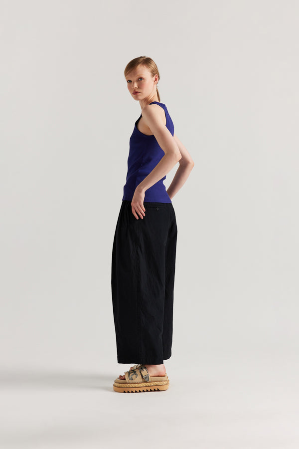 Back angle of Model wearing the Wing tank in Cobalt blue. A slim-fit ribbed cotton tank with a slight racer neckline. A clean, minimal silhouette