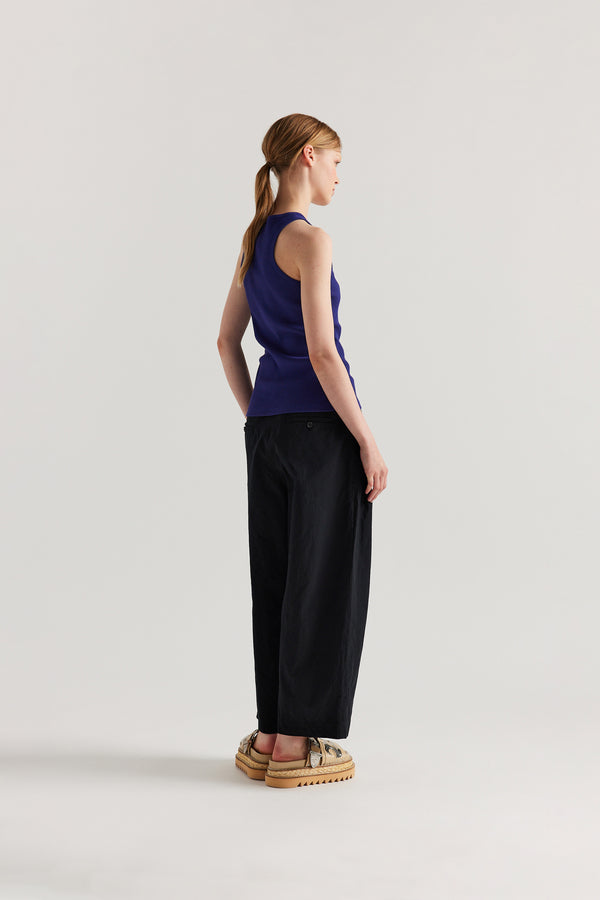 Back angle of Model wearing the Wing tank in Cobalt blue. A slim-fit ribbed cotton tank with a slight racer neckline. A clean, minimal silhouette