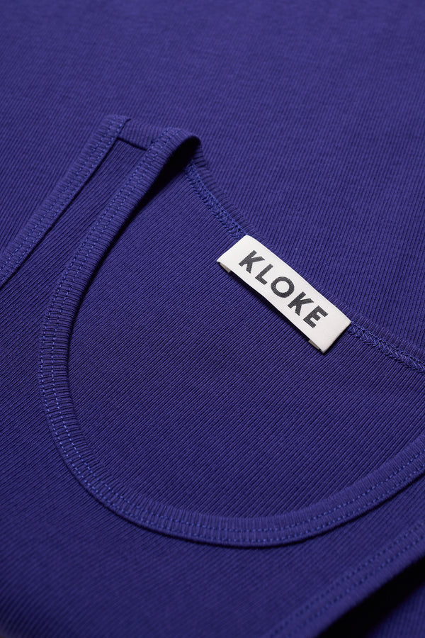 detail shot of the Wing tank in Cobalt blue. A slim-fit 1x1 ribbed cotton tank with a slight racer neckline. A clean, minimal silhouette
