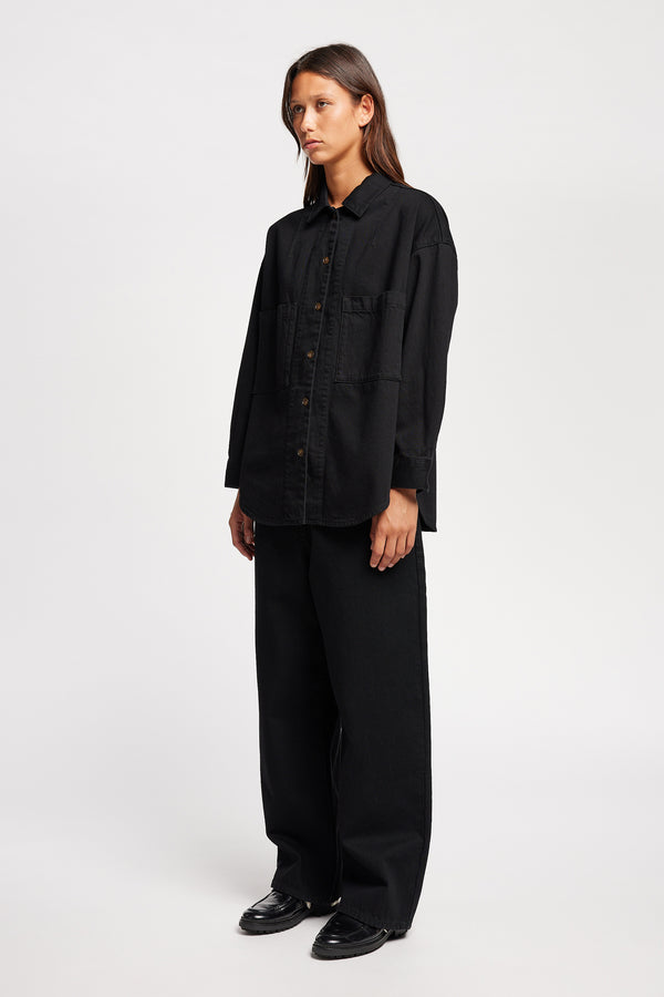 Front angle view of Model wearing Kloke straight-leg jeans in black Japanese denim, featuring a mid-rise waist and relaxed silhouette