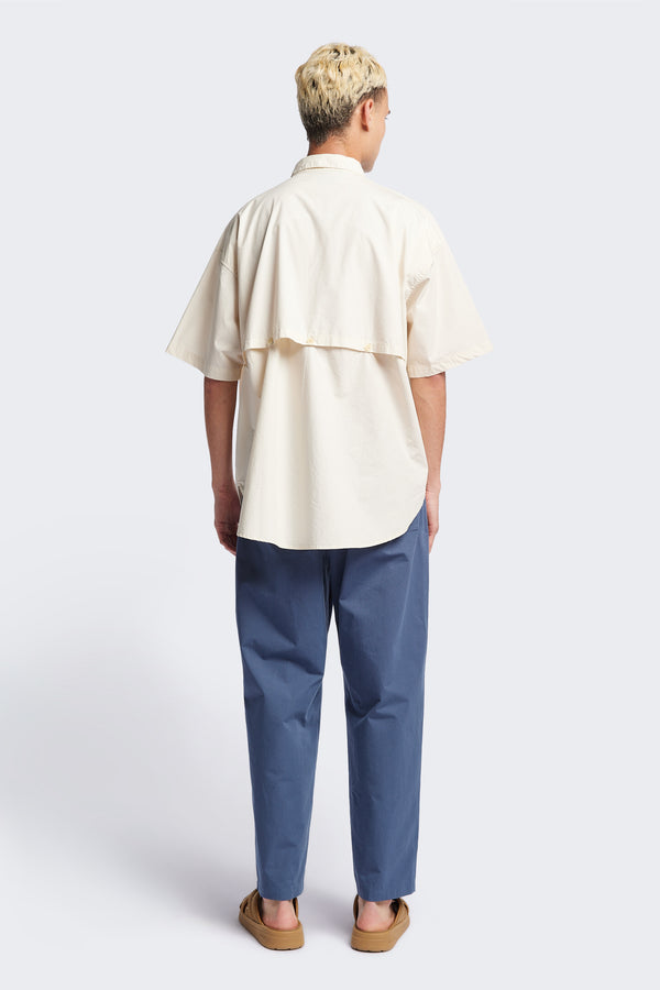 (men) Relaxed loose-fitting boxy short-sleeve shirt with back button placket, scoop hemline, and chest patch pockets, crafted in lightweight cotton poplin. Available in 5 sizes.  