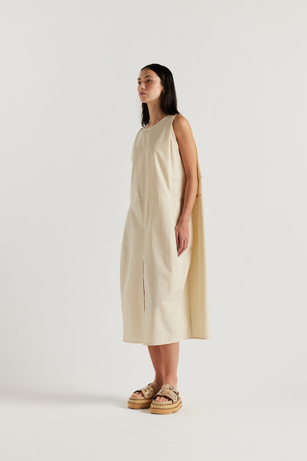 Front angle of female model in the cream Aureole Dress in textured seersucker with a relaxed, sleeveless silhouette