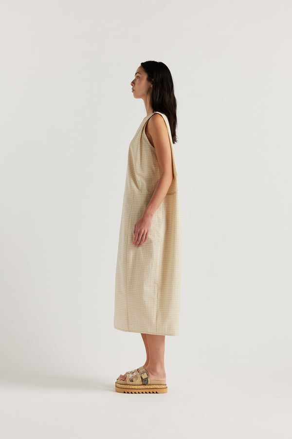 Side view of the cream Aureole Dress showing its boxy silhouette and relaxed fit.