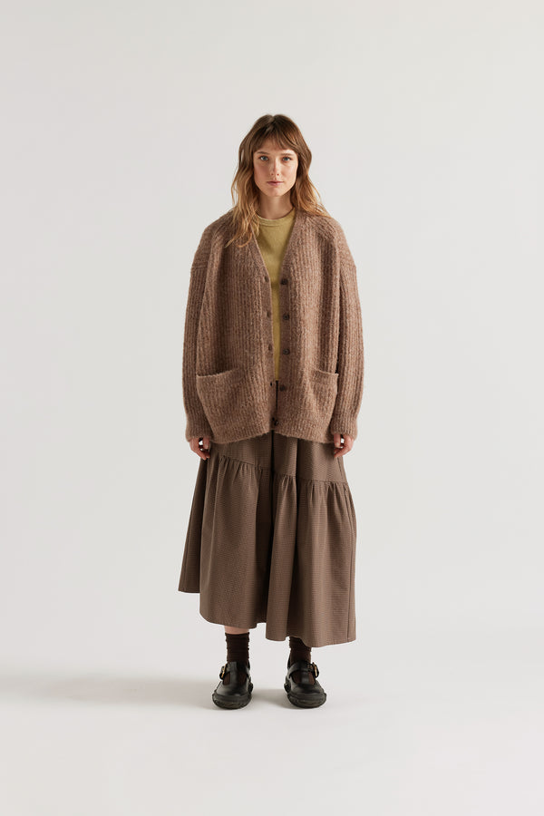 Female model in Walnut Bloom Cardigan worn open and layered over a Tee and Skirt, showing relaxed oversized silhouette and fluffy alpaca blend texture