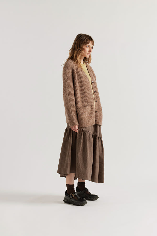 Female model in Walnut Bloom Cardigan worn open and layered over a Tee and Skirt, showing relaxed oversized silhouette and fluffy alpaca blend texture