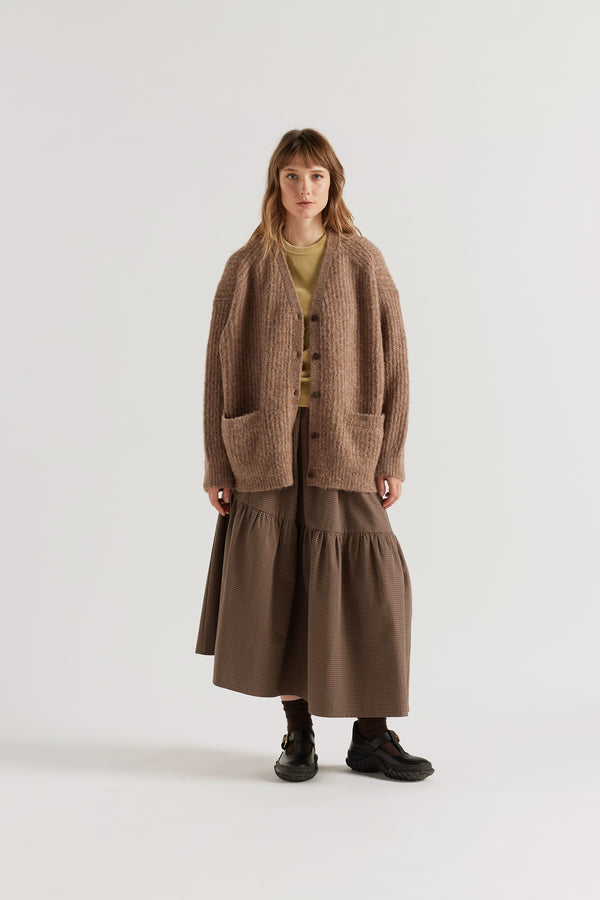 Female model in Walnut Bloom Cardigan worn open and layered over a Tee and Skirt, showing relaxed oversized silhouette and fluffy alpaca blend texture