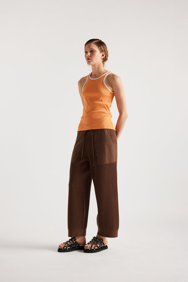 Model wears KLOKE knit pant in brown, angled front view
