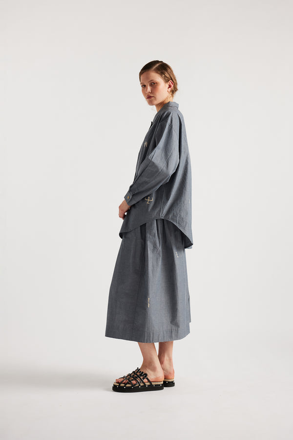 Model wearing KLOKE embroidered shirt in blue grey, side view