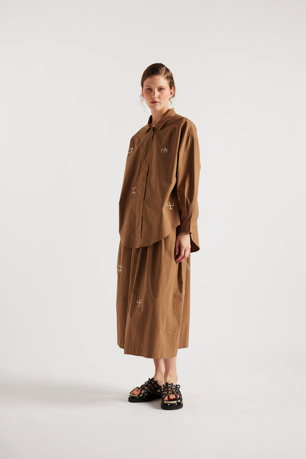 Model wearing KLOKE embroidered shirt in walnut brown, angled front view