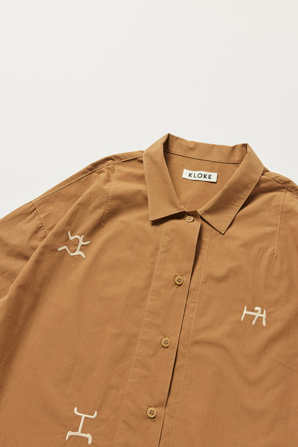 Detail of KLOKE embroidered shirt collar and shoulder darts in walnut brown, front view