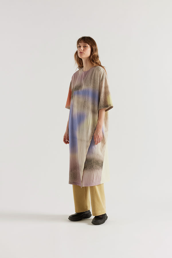 Eon Dress in Aion Print layered over the Sedate Lounge Pant showing daytime styling and fluid asymmetric midi silhouette in fragmented mauve, blue and orange print