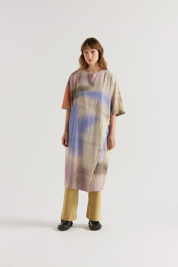 Eon Dress in Aion Print layered over the Sedate Lounge Pant showing daytime styling and fluid asymmetric midi silhouette in fragmented mauve, blue and orange print