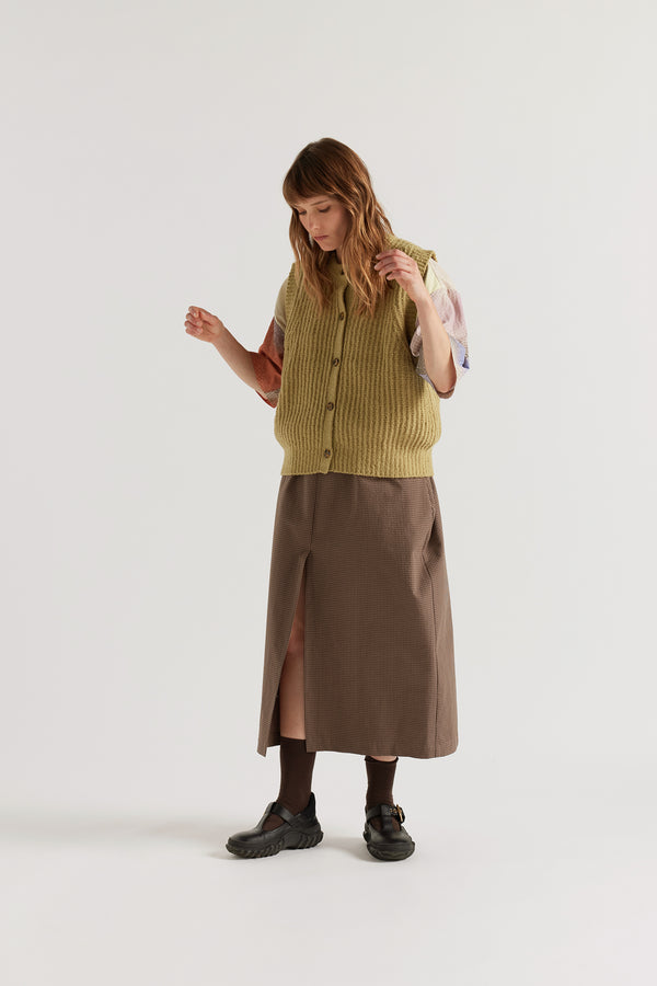 Faint Knit Vest worn buttoned over a Top, showing centre-front button placket, tubular rib neckline and reverse half-cardigan rib construction